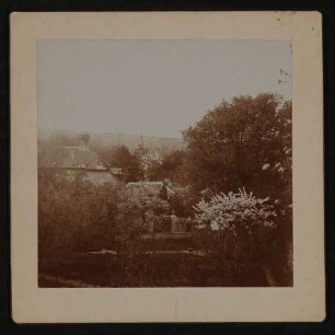 Garten von Hofmannsthals Rodauner Haus im Frühling, Blick von oben vom Kirchplatz auf das Hausdach und die Landschaft dahinter