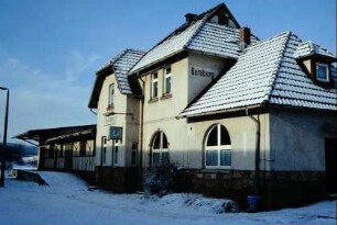 Rückseite des Bahnhofgebäudes mit Uhr, angebautem Güterschuppen und Rampe