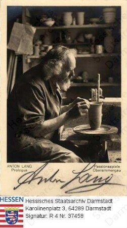 Lang, Anton (1875-1938) / Porträt in der Töpferwerkstatt bei der Arbeit, sitzend, Kniestück / mit Bildlegende 'Anton Lang Prologus Passionsspiele Oberammergau' und eigenhändiger Unterschrift