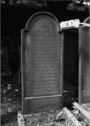 Grabstein 131 (Index: 100094241) Material: Sandstein Zustand: unten abgeblättert Maße HxBxT: 193x74x17 cm Beschreibung: Stele, eingezogener Rundbogenabschluß, Schriftfeld eingetieft Besonderheit: langes Lobgedicht: Grabstein 131