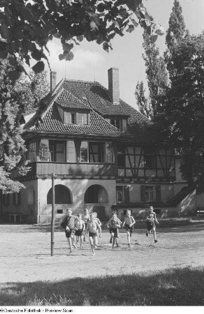 Jungengruppe auf einem Sportplatz vor einer Jugendherberge
