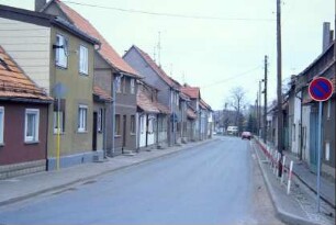 Dorfstraße mit geschlossenen Häuserzeilen, davon einige einstöckig