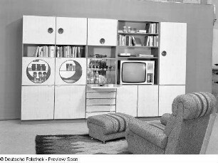 Anbauwand "Standard" : Wohnzimmermöbel (1973). Ansicht mit Anbauwand und Sessel mit Hocker