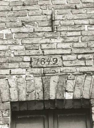 Schleife, Friedensstraße 68. Pfarrhof. Teilansicht eines Nebengebäudes (1849) mit Inschriftenstein