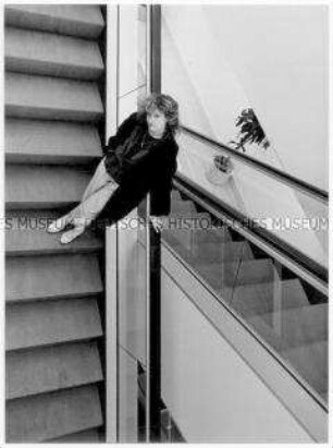 Junge Frau auf Rolltreppe (Altersgruppe 14-17)