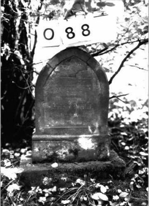 Grabstein 88 (Index: 100101308) Material: Sandstein Zustand: stark verwittert mit Textverlust Maße HxBxT: 69x40x12 cm Beschreibung: Stele, getreppter Sockel, Spitzbogenabschluß Besonderheit: Kindergrab: Grabstein 88