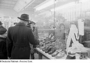 Messebesucher vor einer Vitrine mit Schuhen