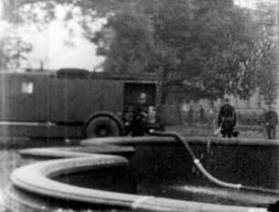 Zerstörungen Zweiter Weltkrieg. Löschfahrzeug mit Feuerwehrmännern bei Wasserentnahme aus dem Brunnen am Friedrichsplatz