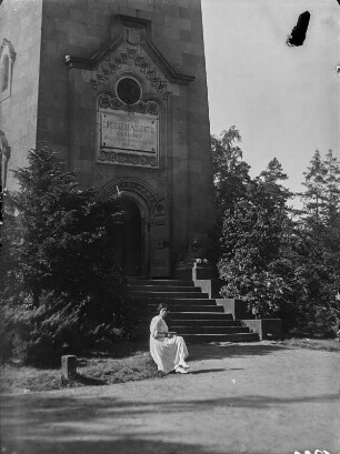 Am Friedrich-August-Turm : Eine Frau sitzt vor dem Friedrich-August-Turm auf dem Rochlitzer Berg.
