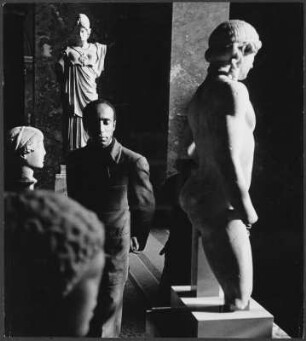Mann zwischen antiken Statuen im Louvre, Paris