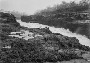 Der "Ferrador" : Männer sitzen am Ufer des "Ferradors" des Rio Grande. Im Flusslauf Stromschnellen.
