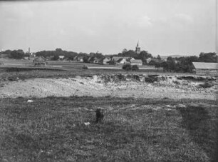 Dorf : Blick über ein Feld auf ein Dorf