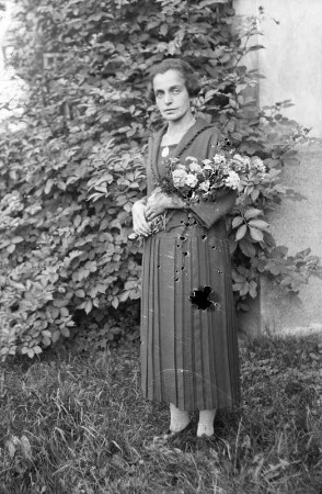 Frau mit Blumenstrauß in einem Garten