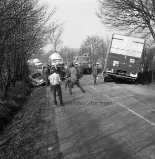 Verkehrsunfall: Landstraße zwischen Hammoor und Bargteheide: Langehorst / Lohe: Kollision eines VW-Käfer mit einem Lkw: rechts verunglückter Lkw im Straßengraben: links Unfall-Pkw: dazwischen mehrere Polizisten, Helfer und Zuschauer: hinten Mitte Feuerwehrfahrzeug, Lkws und Polizeifahrzeug: rechts und links Bäume und Büsche