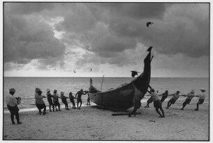 Alappuzha. Fischer ziehen ein Fischerboot an Land