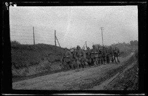 "Vermutlich an der Straße Fins - Nurlu (beide Dep. Somme, Frankreich)": "marschierende Infanterie mit Stahlhelmen" auf einer unbefestigten Landstraße (Vorderansicht)