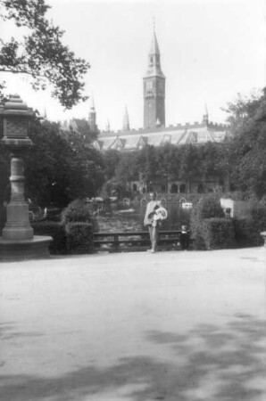Ernst Otto Gerhardt neben einer Steinlaterne. Blick auf eine Burg- oder Schlossanlage