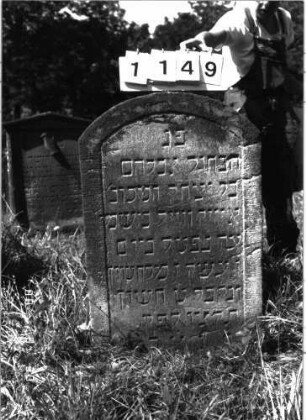 Grabstein 1149 (Index: 100098671) Maße HxBxT: 97x58x10 cm Besonderheit: kulturhistorisch wertvoll / hist.-wiss. Gründe (Gemeindestellung): Grabstein 1149