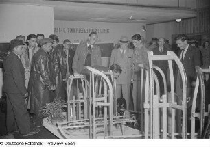 Besucher an einem Messestand mit Schlitten