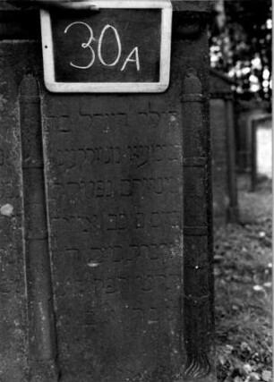Grabstein 30 (Index: 100111064) Material: Sandstein Zustand: beschädigt und verwittert Maße HxBxT: 128x75x17 cm Beschreibung: Doppelstele, Giebel Symbolik: drei gesenkte Fackeln, Blätterfries Besonderheit: Doppelgrab; - Kindergrab: Grabstein 30A