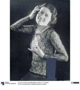 Frau in Kleid mit Parfümflakon