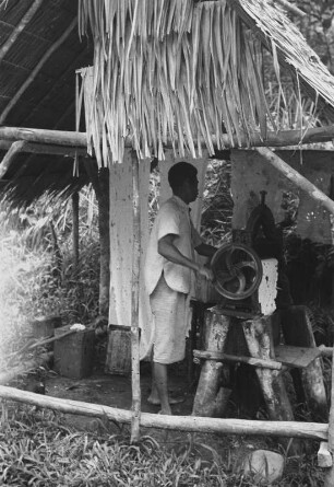 An der Kautschukmühle : Dorfbewohner in einer Hütte an einer Kautschukmühle