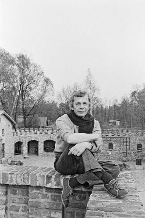 Der Schriftsteller Peter Hacks im Freien, aauf einer Mauer sitzend