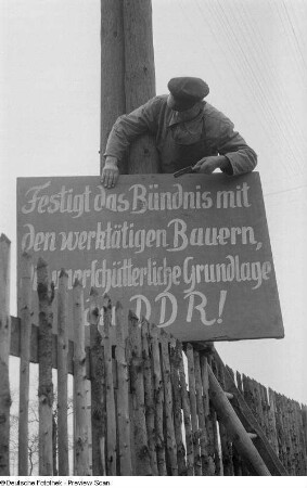 Anbringen eines Schildes mit politischer Propaganda für die DDR