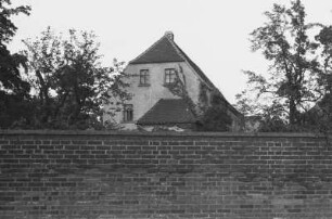 Ein Haus : Haus hinter einer Backsteinmauer