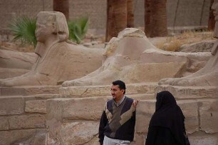Luxor - Verschleierte Frau : Junges ägyptisches Paar, Frau verschleiert, posiert vor der Sphinx-Allee im Luxor-Tempel, aufgenommen 2006 in Luxor