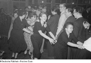 Gäste einer Betriebsweihnachtsfeier beim Tanzen einer Polonaise