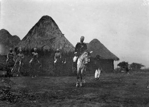 Njoya zu Pferde mit berittenen Soldaten.