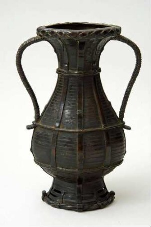 Vase in Gestalt einer geflochtenen Flasche