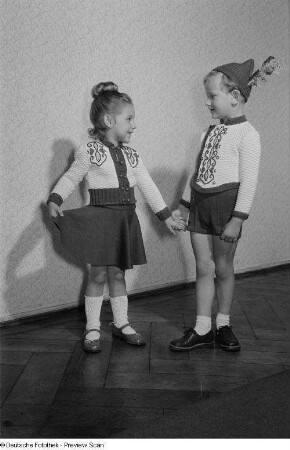 Ein Junge und ein Mädchen präsentieren Kinderbekleidung