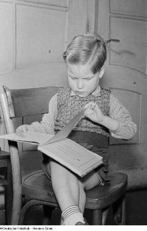 Porträt eines kleinen Jungen beim Lesen eines Buchs