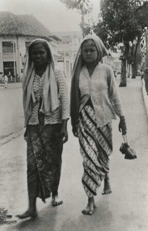 Java, Indonesien. Koloniale Küstenstadt. Zwei sudanesische Frauen, bekleidet mit Bluse, Sarong und Slendang
