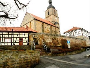Ansicht von Südwesten mit Kirche über Kirchhofmauer sowie anschließende (erneuerte) Gaden in Fachwerk-Ausführung