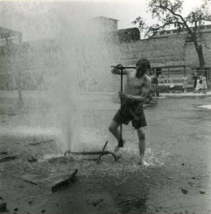 Berlin. Mann beim Schließen eines Hydranten, von dem sich das Standrohr mit Auslaufventil (Bhelefs-Trinkwasserzapfstelle) gelöst hatte
