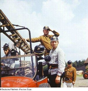 Historisches Feuerwehrauto mit Besatzung in historischen Uniformen