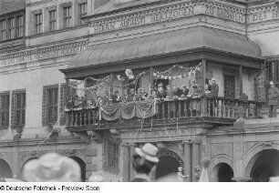 Karnevalsteilnehmer auf dem Balkon des Alten Rathauses