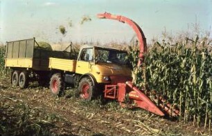 Fotografie: Maishäcksler angebaut, Frontanbau, Systemtraktor, Zweiachsanhänger