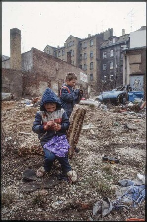 Leipzig, März 1992. Sanierungsgebiet Lindenau. Schrott am Strassenrand, wilde Müllkippe, spielende Kinder