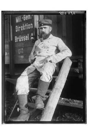 Portrait eines Soldaten : 1. Weltkrieg. Soldat in Uniform mit Pfeife auf der Treppe eines Eisenbahnwaggons sitzend, 1914/1918