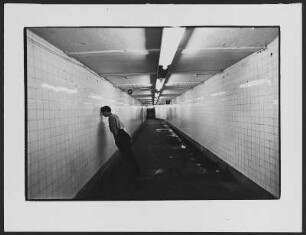 U-Bahnstation : Junger Mann im braunen Hemd der Hitlerjugend in einem Tunnel der New Yorker U-Bahn, mit der Stirn an die gekachelte Wand gelehnt