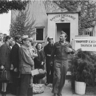 Berlin (West). Berliner und uniformierte US-Amerikaner vor dem Eingang zum Tausch-Ring (Serie "Radio gegen Lucky Strike")