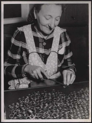 Frau beim Entgraten von Bauteilen