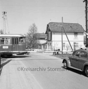 Sülfeld: Elmenhorster Chaussee: Bahnübergang der Elmshorn-Barmstedt-Oldesloer Eisenbahn (EBOE): rechts VW-Käfer: in der Mitte geschlossene Bahnschranken: links Triebwagen: hinten rechts und Mitte Häuser