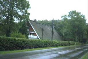 Fuhrwegen: traufständiges Bauernhaus mit Reetdach: nach Umbau: Straßenfront: Giebelseite, eingeschossiger Anbau mit Altan: Gartenhecke