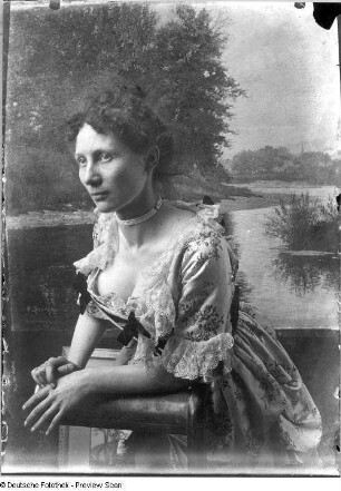 Eine Angehörige der Familie Quarck vor einem Gemälde des Künstlers im Festkleid posierend