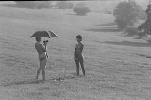 Čičmany. Akt-Pleinair 1980. Günter Rössler (unter einem Schirm) fotografiert eine stehende junge Frau